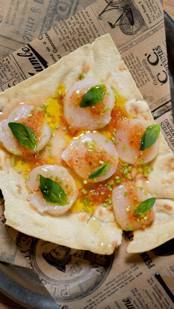 Rohe Kammmuscheln mit Yuzu-Kosho-Dressing und Basilikum auf Fladenbrot