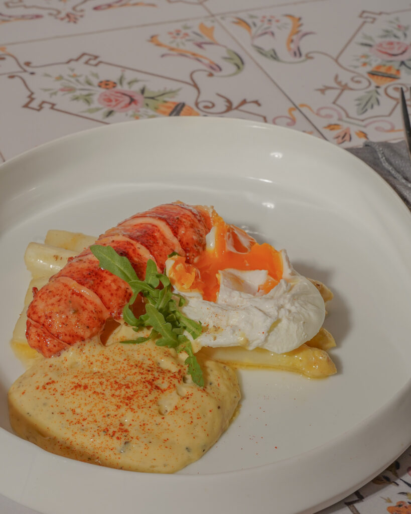 Hummerschwanz auf weißem Spargel mit porchiertem Ei und Trüffelhollandaise