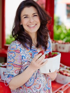 Véronique Witzigmann mit einer Schale frischer Erdbeeren